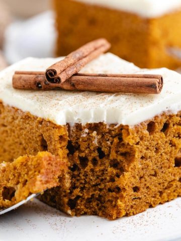 Close up view of pumpkin cake sprinkled with cream cheese frosting.
