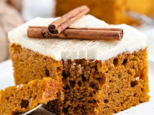 Close up view of pumpkin cake sprinkled with cream cheese frosting.