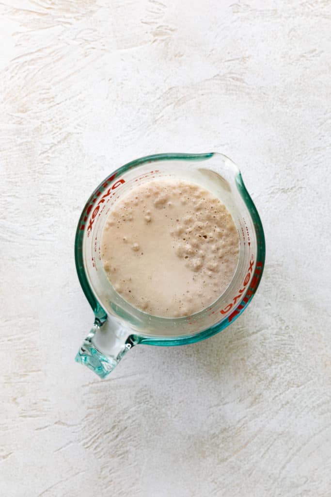 Activated yeast in a measuring cup.