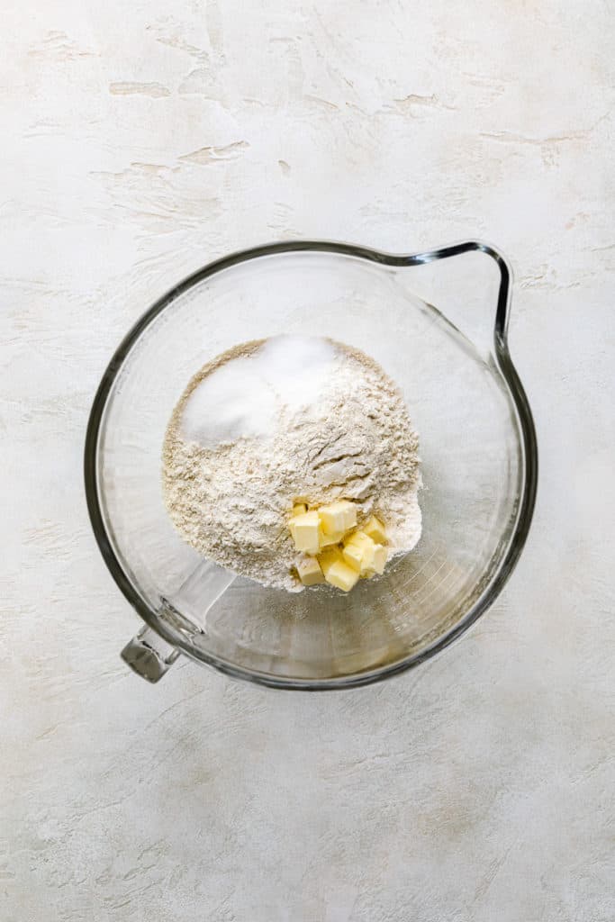 Cubed butter, sugar and flour in a bowl.