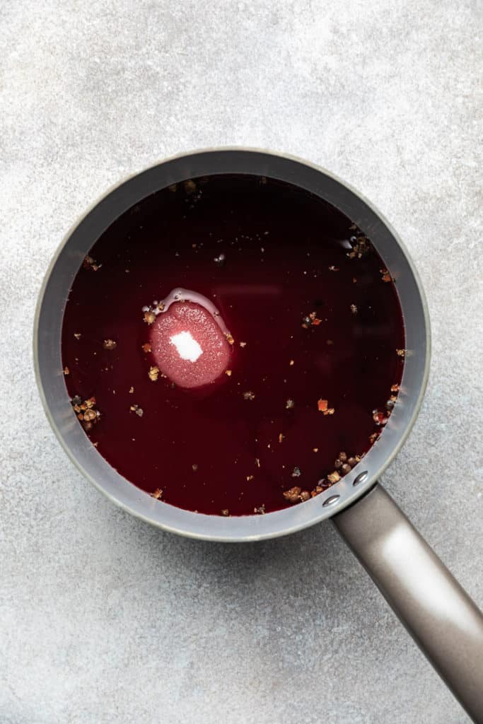 Pomegranate juice, allspice, and sugar in a pan.