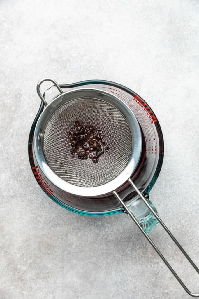 Mesh sieve straining simple syrup.