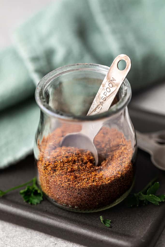 Measuring spoon dipped into a spice blend.
