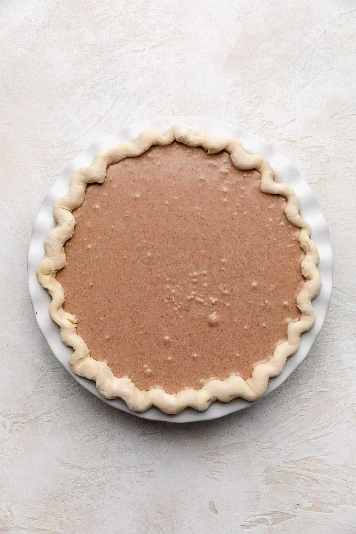 Top down view of unbaked filling in a pie shell.
