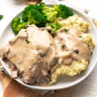 Plate filled with mashed potatoes, pork chops and gravy.