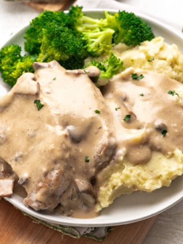 Plate filled with mashed potatoes, pork chops and gravy.
