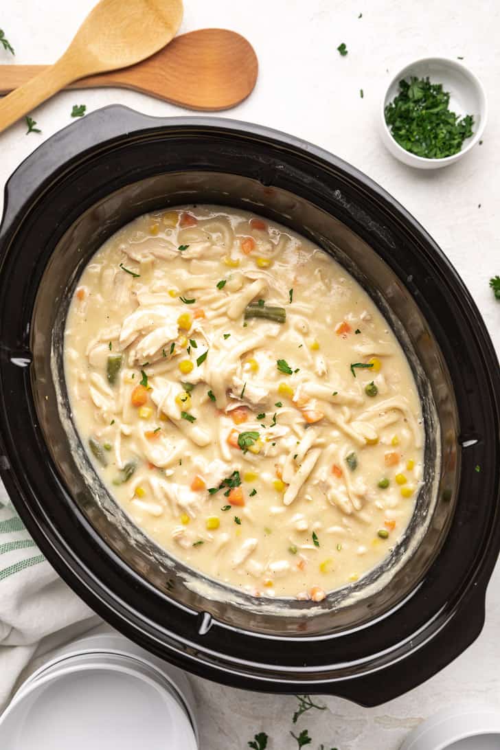 Top down view of a slow cooker filled with chicken and sauce.