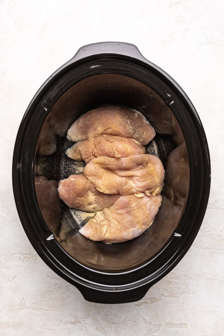 Seasoned chicken breasts in a crock pot.