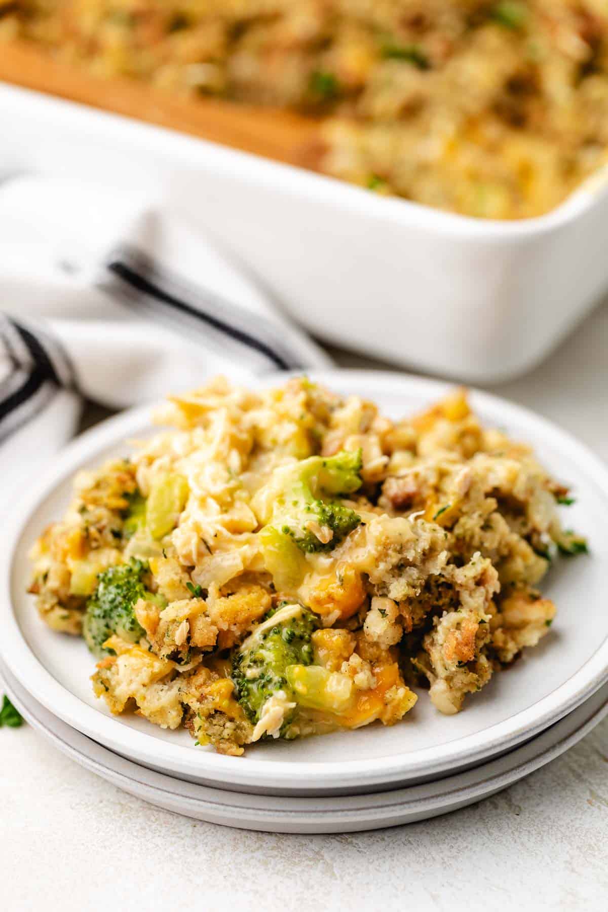 Scoops of chicken and broccoli stuffing casserole on a stack of plates.