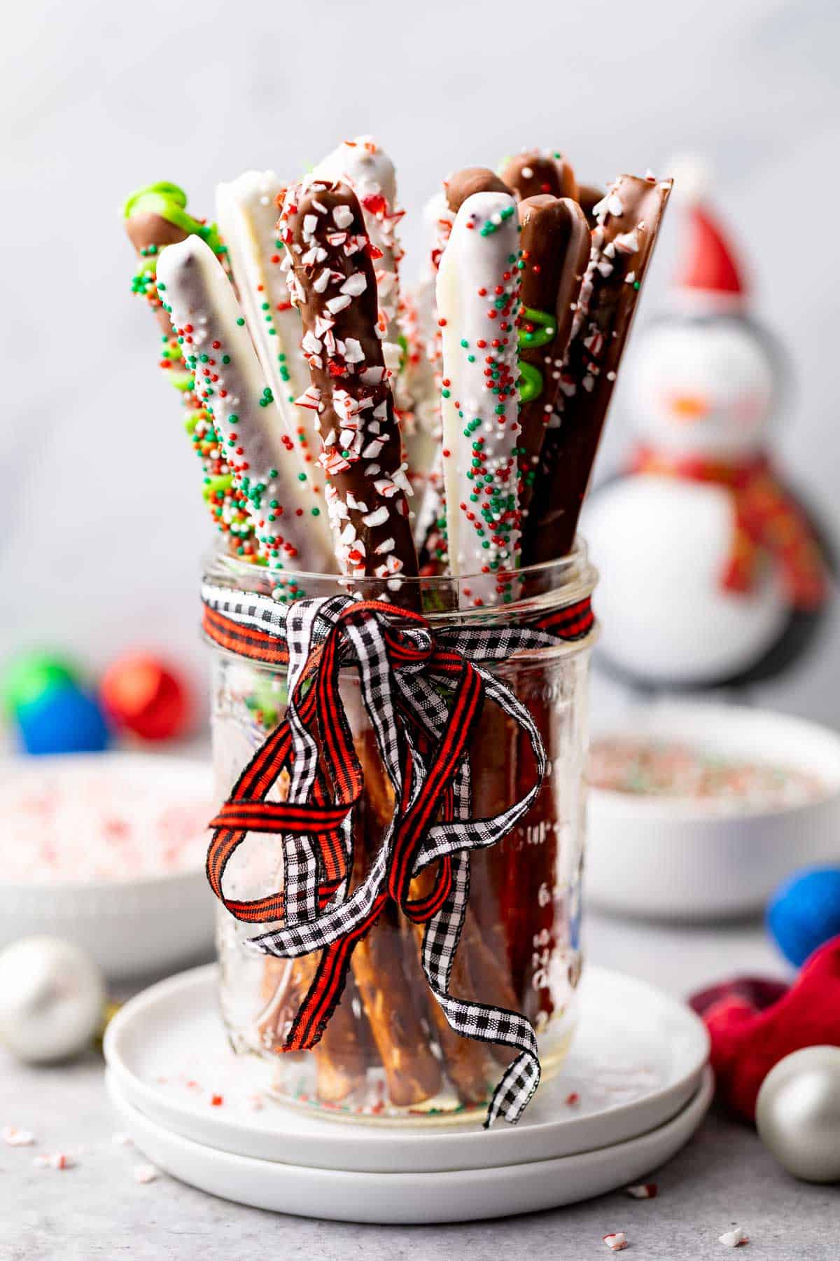 Side view of a mason jar holding chocolate pretzels.