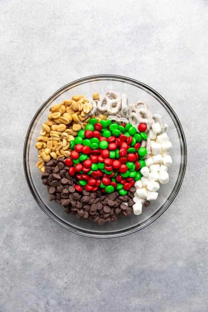 Peanuts, chocolate chips, pretzels, marshmallows, and M&Ms in a bowl.