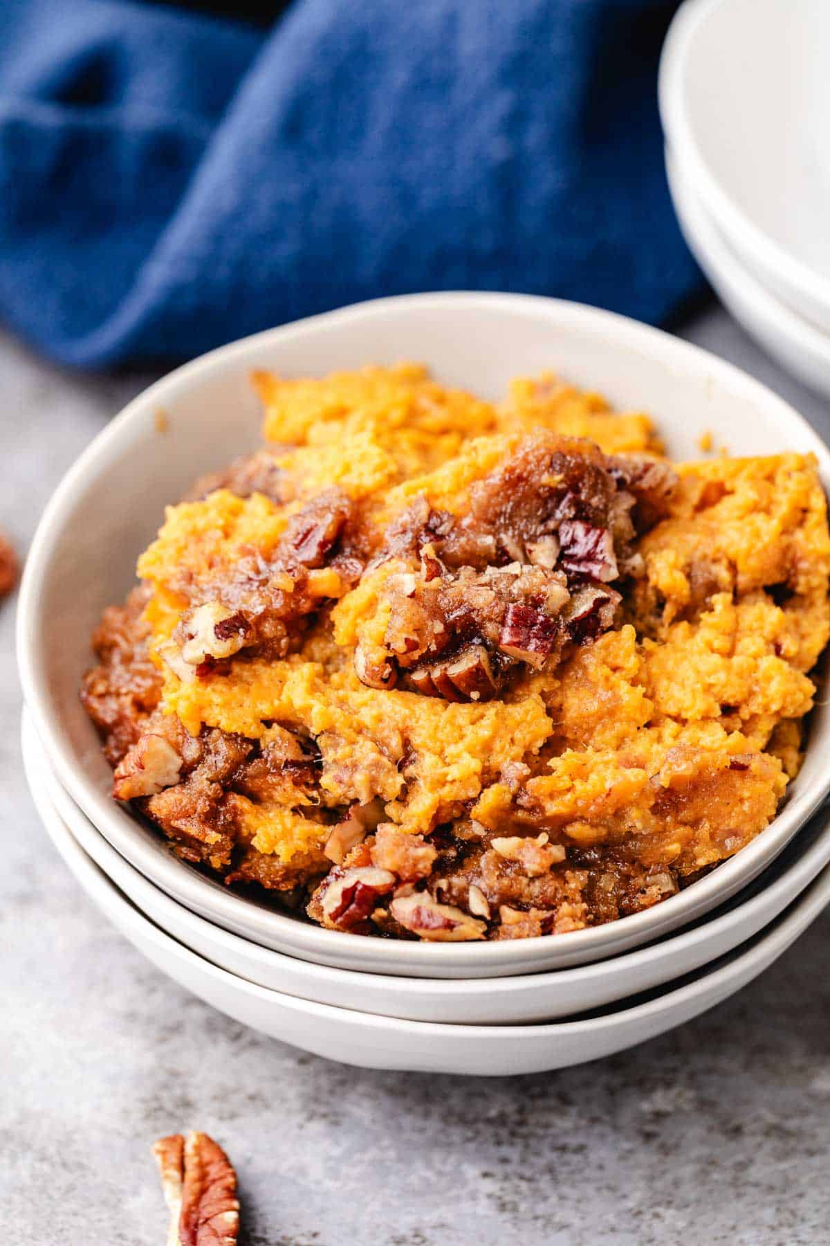 Scoops of sweet potato casserole in a stack of bowls.