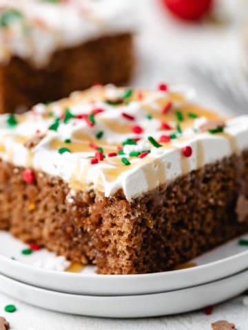 Close up view of two plates holding a piece of Christmas cake with Cool Whip frosting.