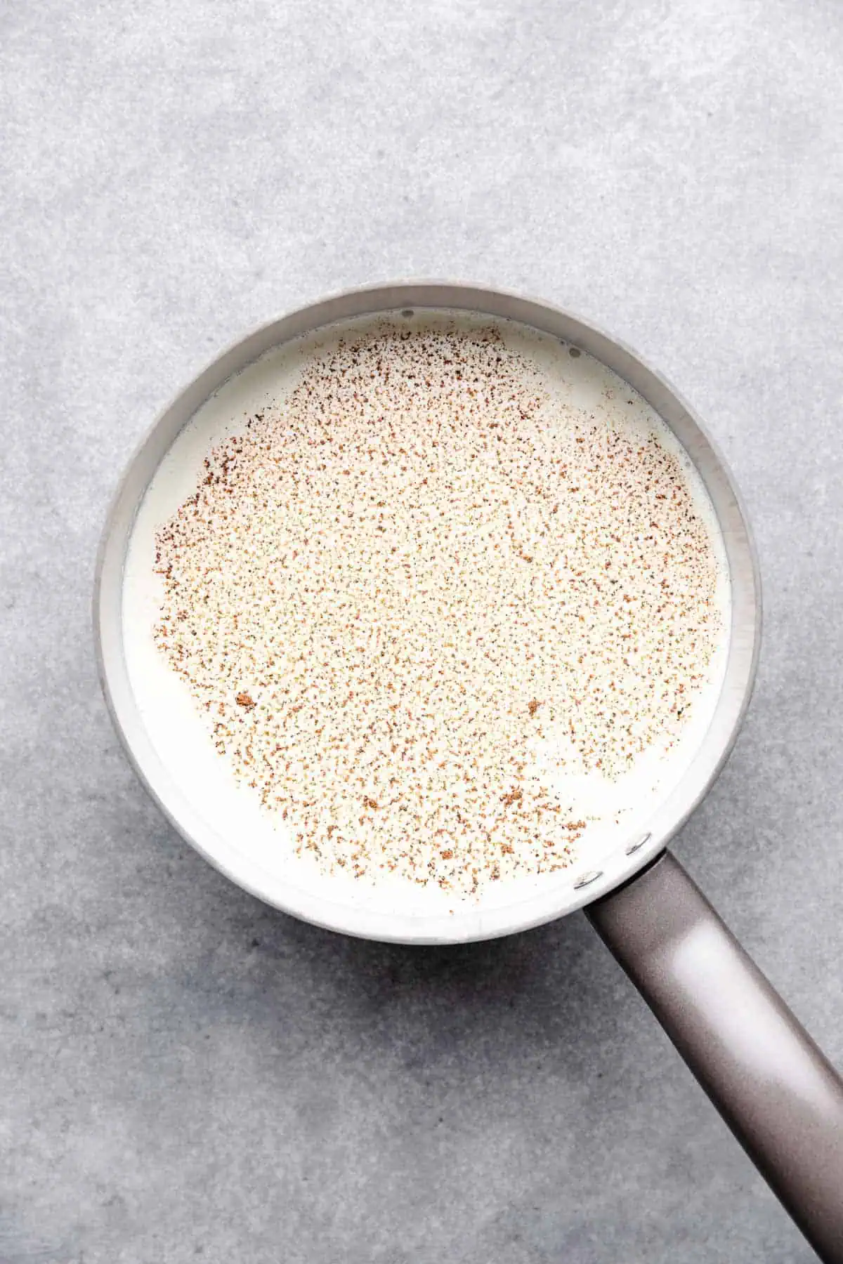 Heavy cream, milk and nutmeg in a saucepan.
