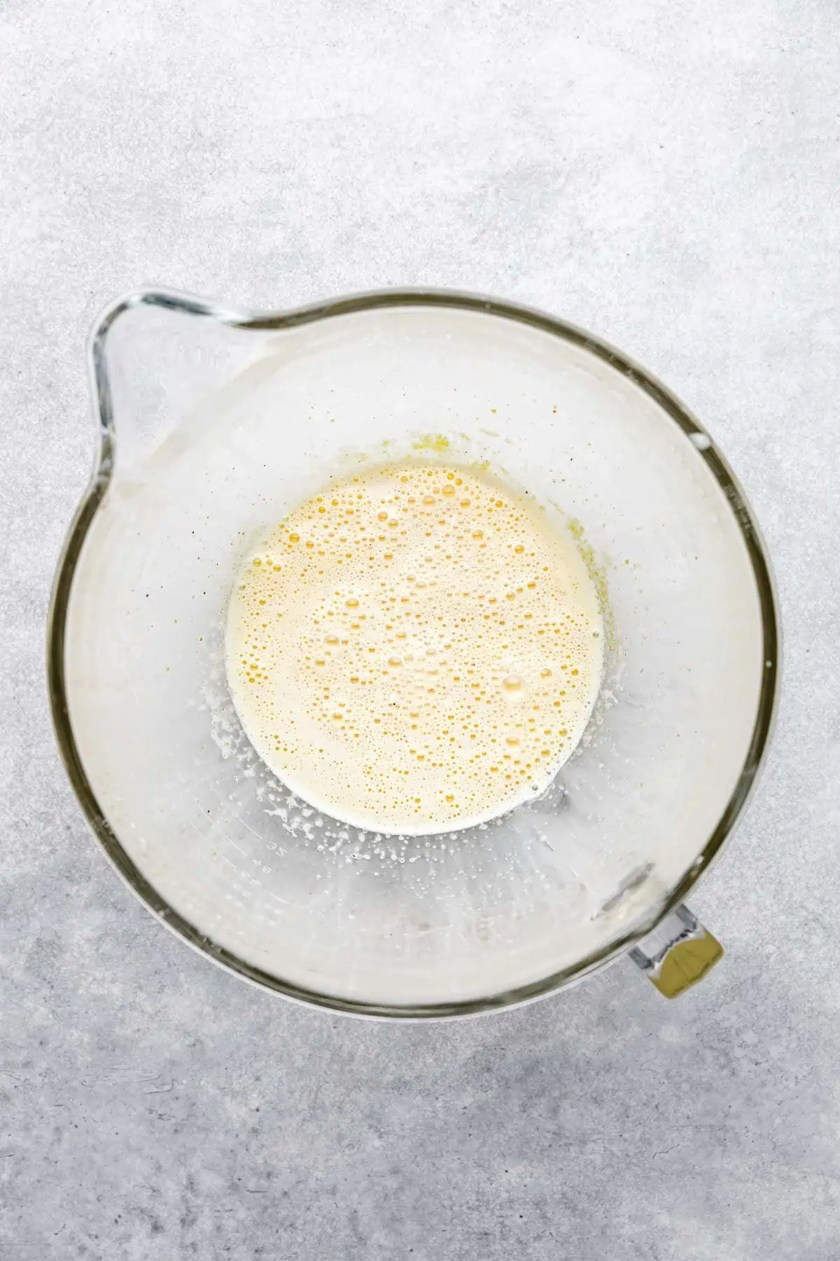 Tempered eggs with heavy cream, milk, and sugar in a bowl.
