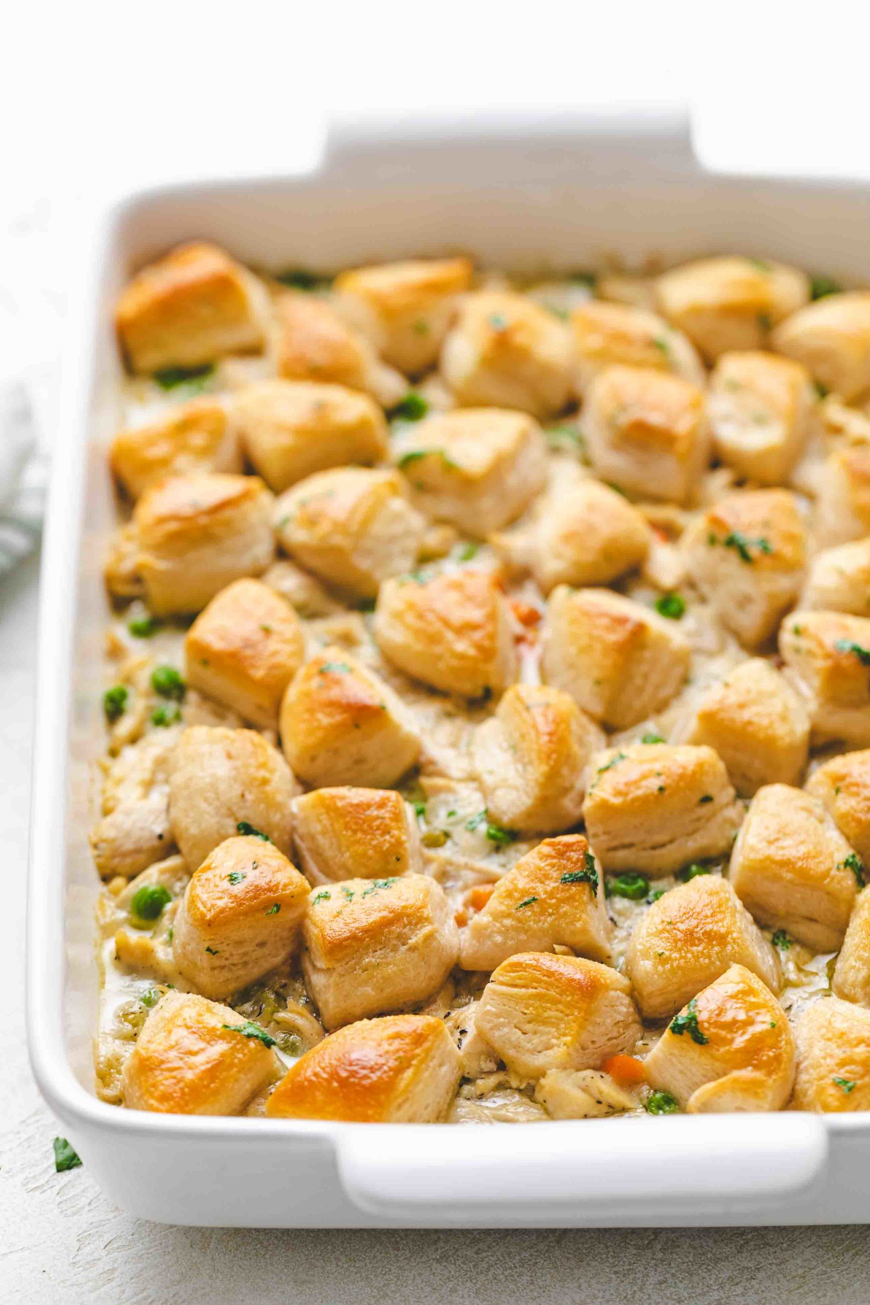 White baking pan filled with biscuits and chicken pot pie.