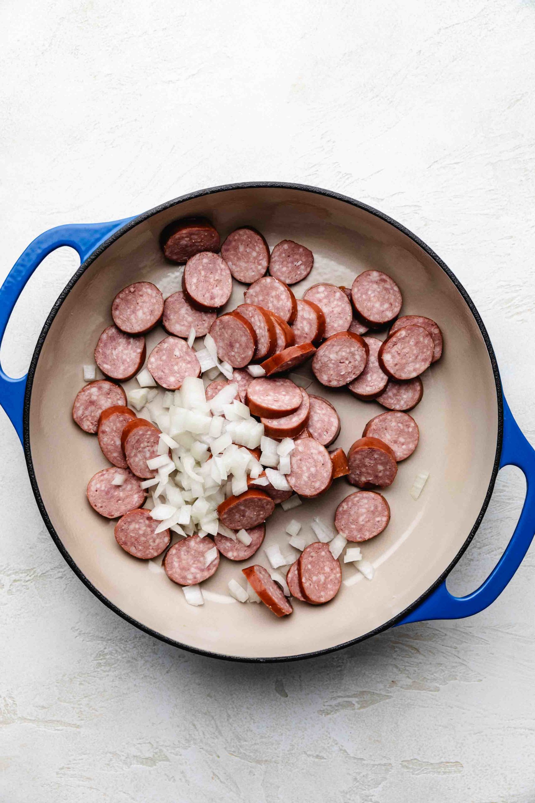 Sausage and onions in a pan.