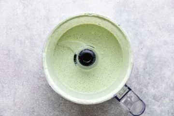 Top down view of cilantro lime crema in a food processor.