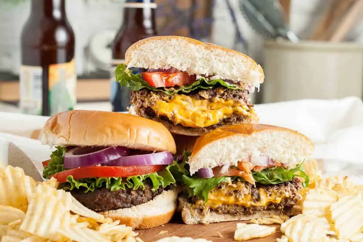 Stack of juicy lucy burgers on a board.