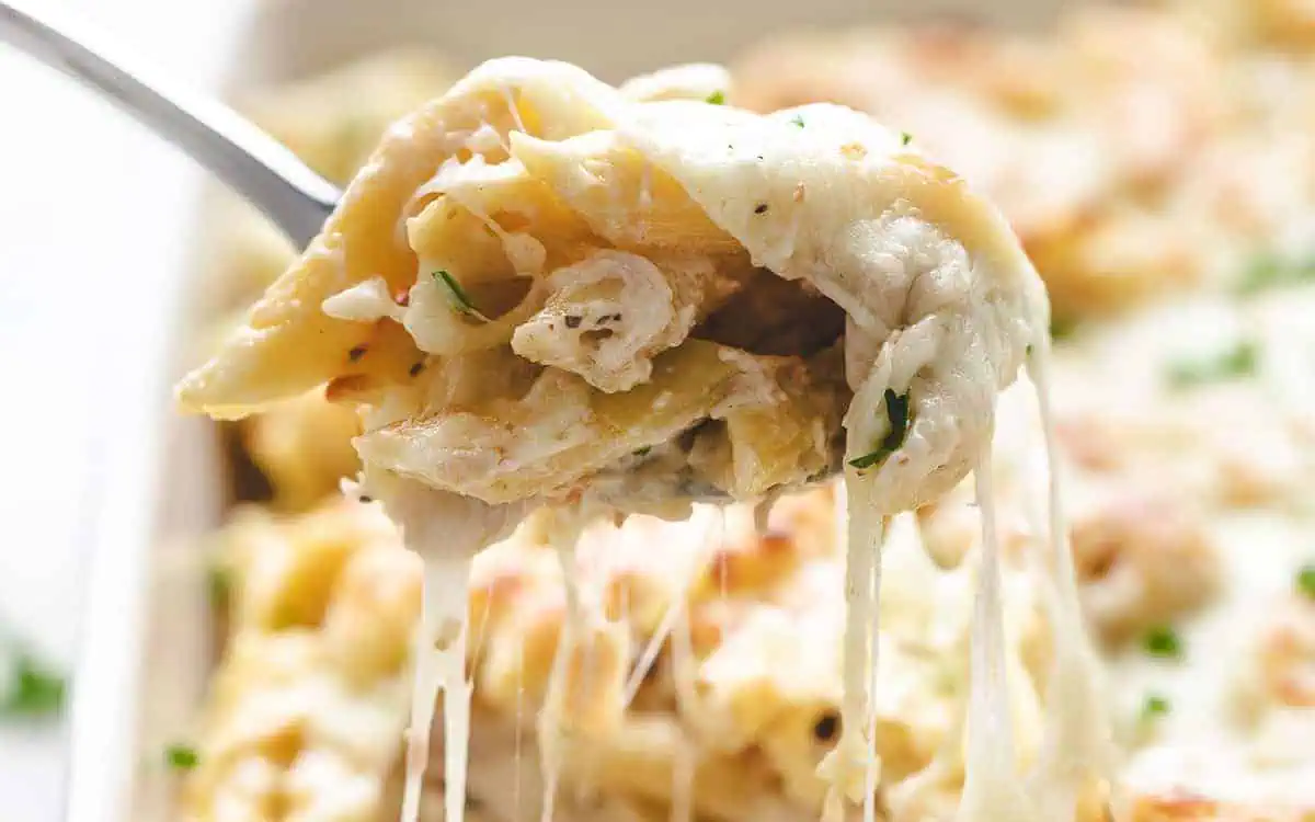 Scoop of chicken alfredo pasta on a spoon.