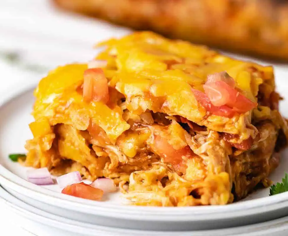 Slice of chicken enchilada casserole on a plate.