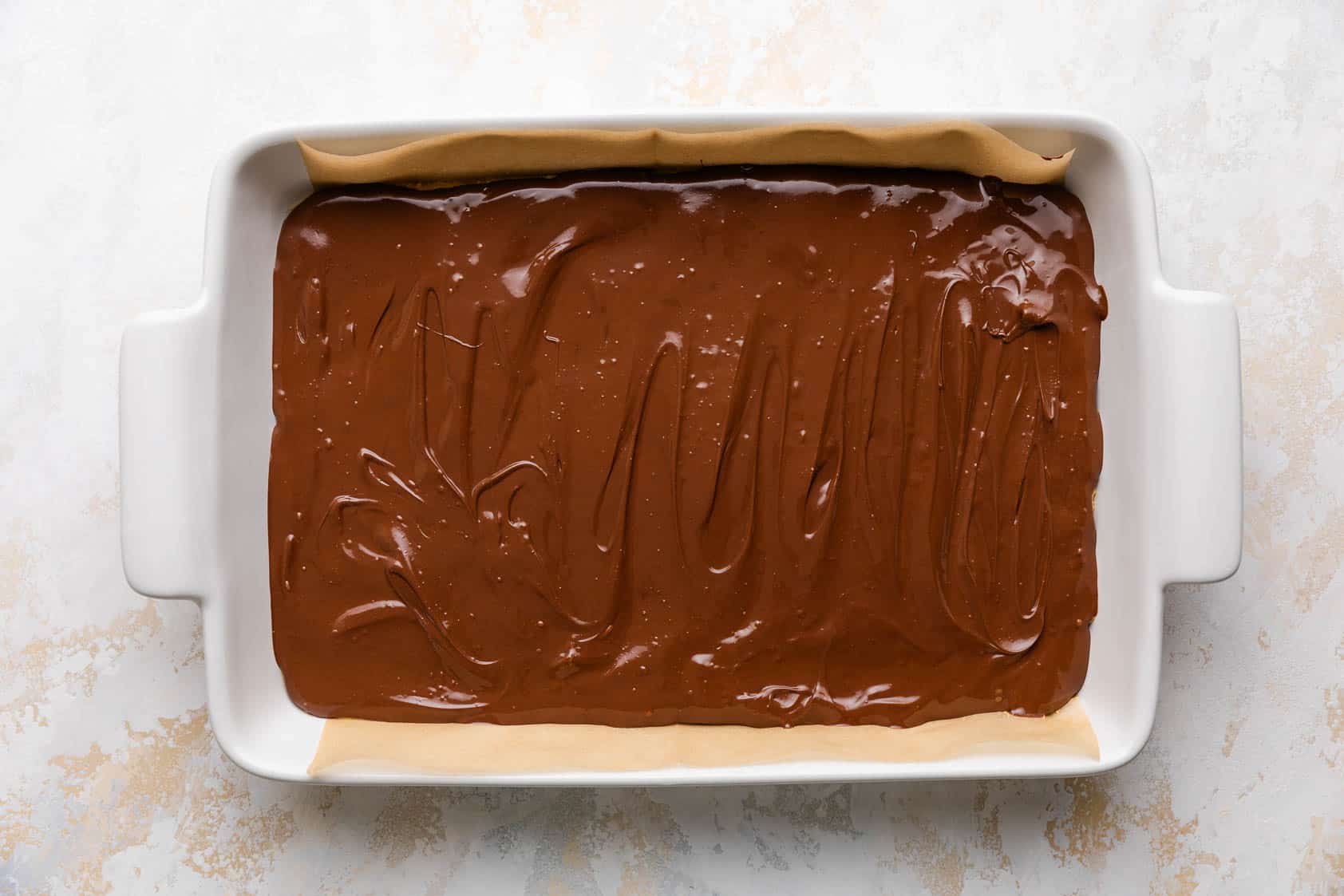 Melted chocolate topping spread over peanut butter.