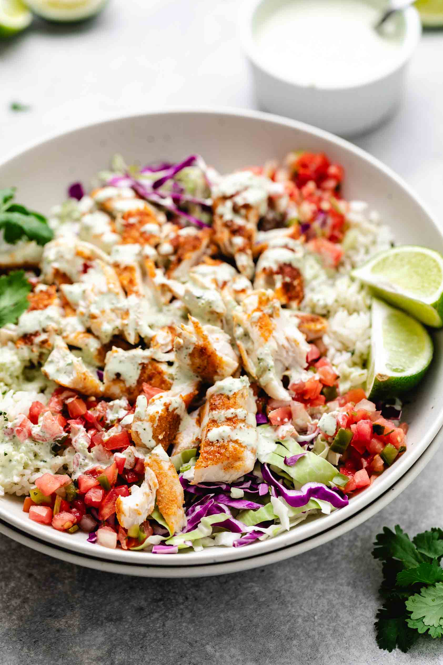 Side view of cilantro lime crema on a taco bowl.