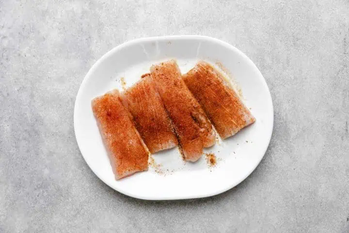Seasoned mahi mahi on a plate.