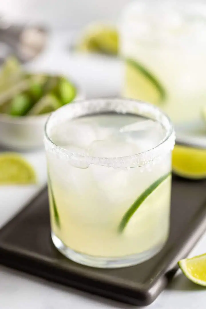 Cocktail with lime in a salt rimmed glass.