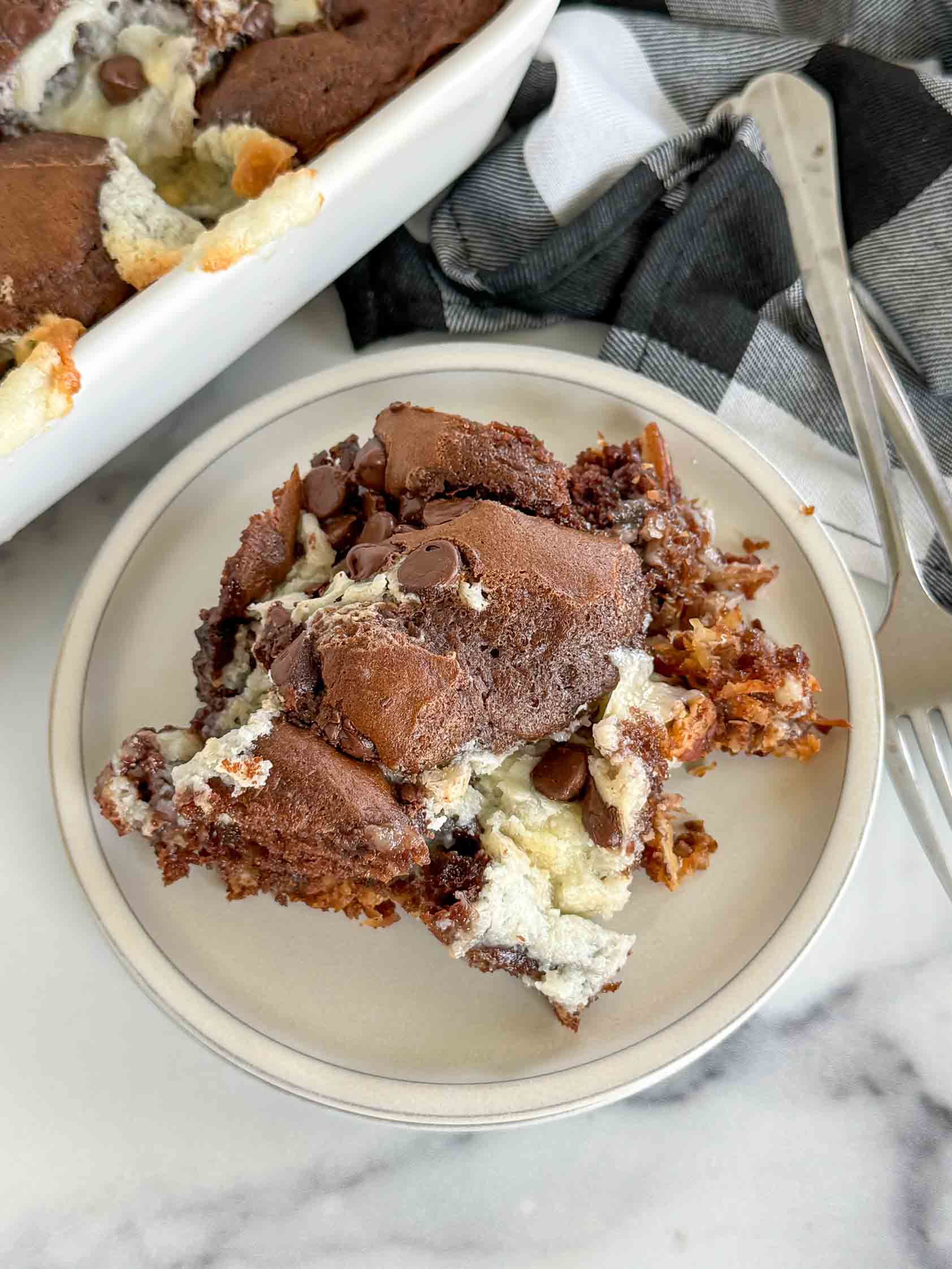 Slice of german chocolate cake on a stack o fplates.