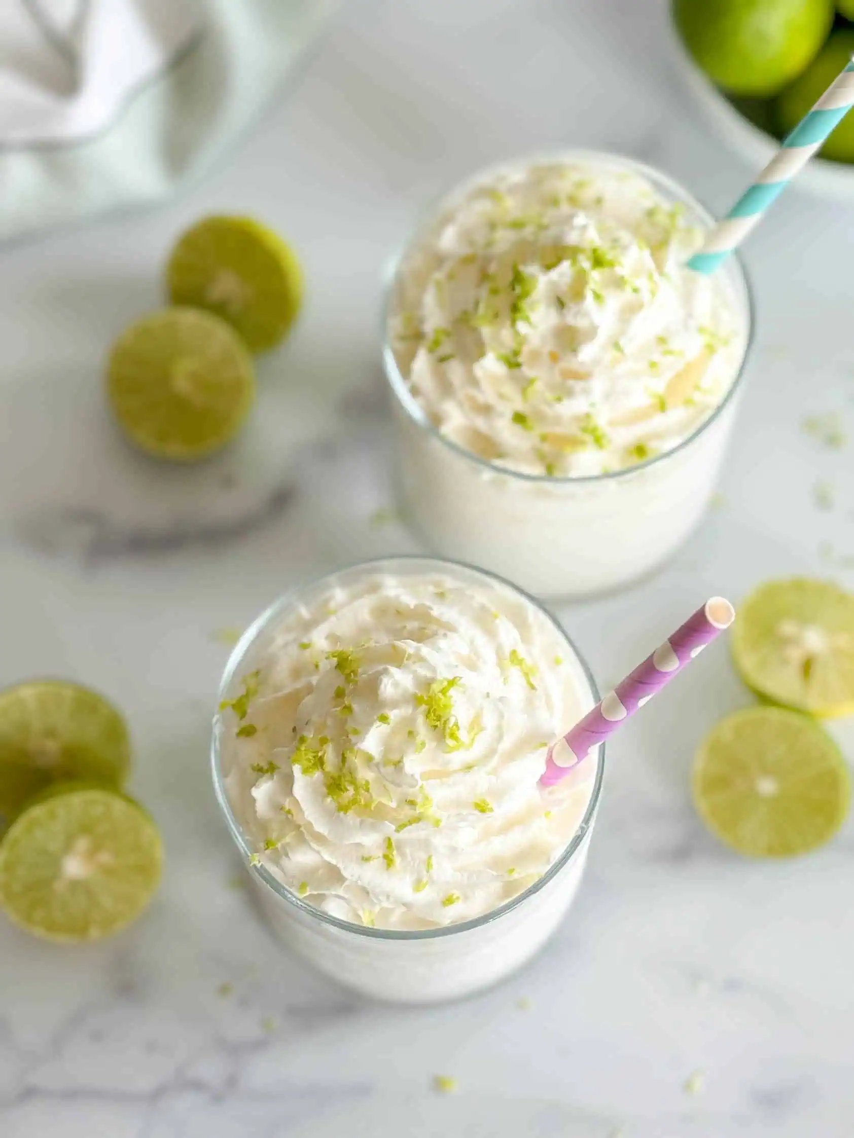 Two key lime coladas with whipped cream.