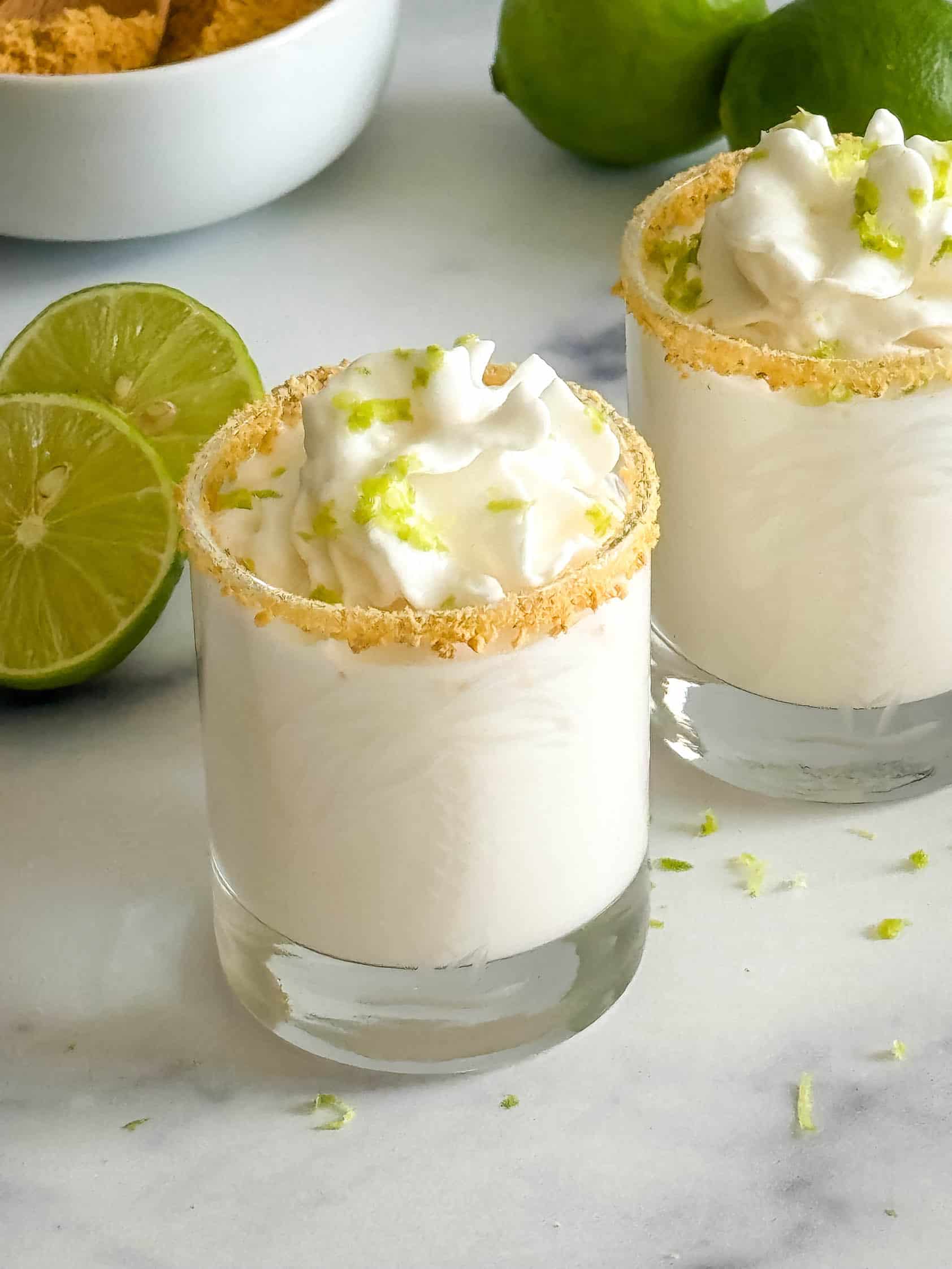 Key Lime Pie Shots Shot glass filled with a creamy drink.