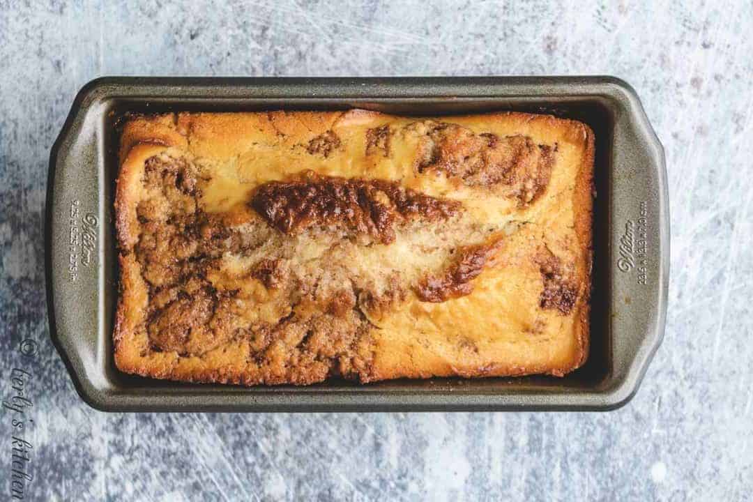 The fresh baked bread cooling in a loaf pan.
