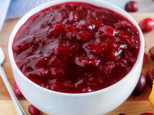 Close up view of cranberry sauce in a white bowl.