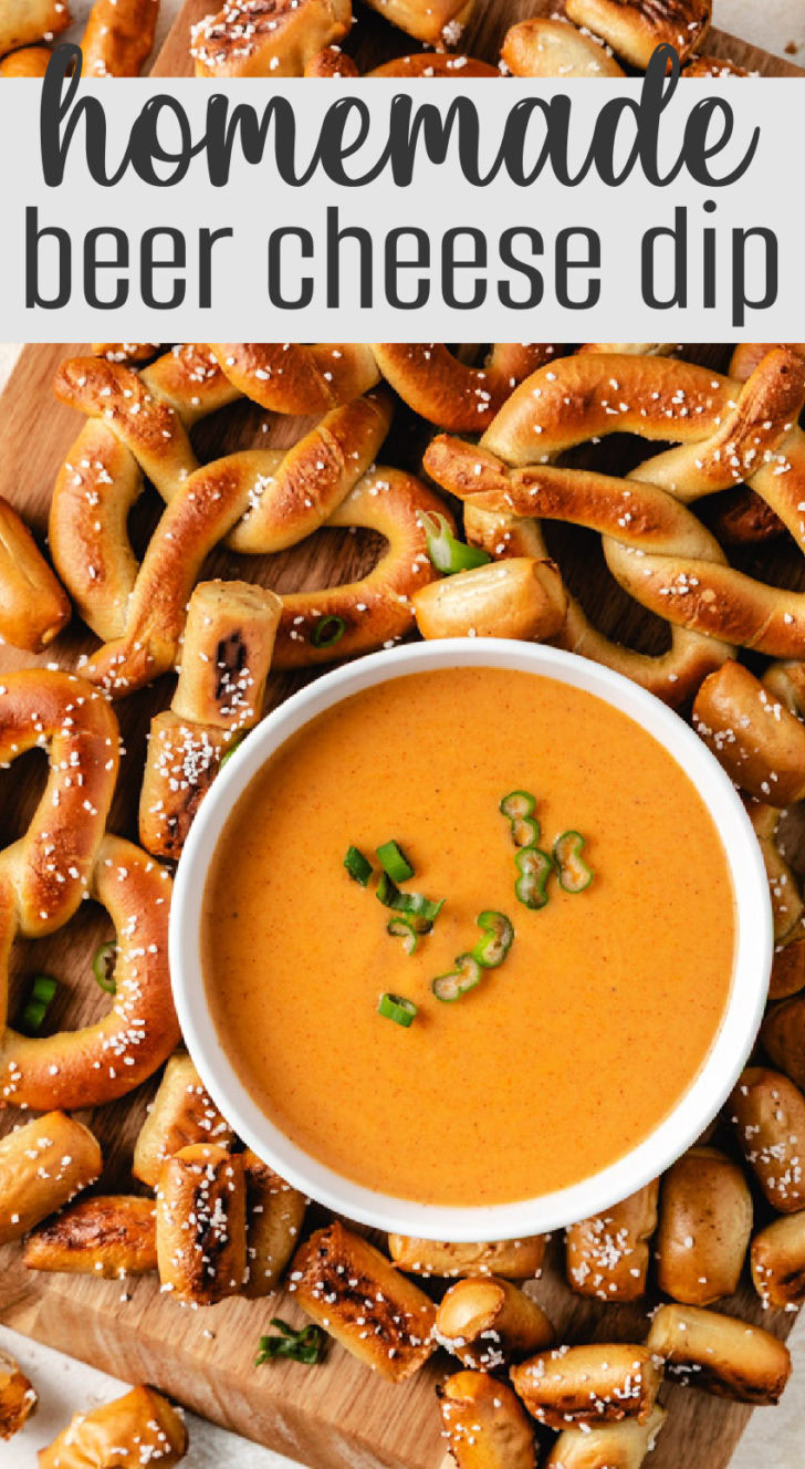 Overhead shot of beer cheese dip in a white bowl, surrounded by golden brown soft pretzels.