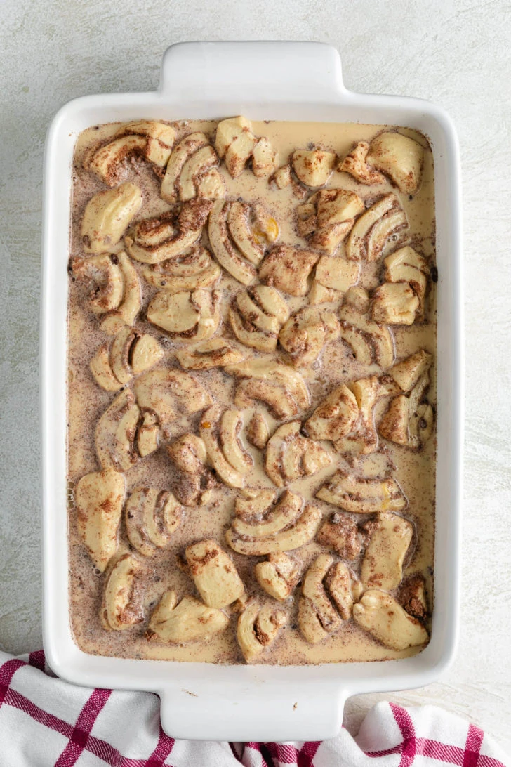 Custard poured over quartered cinnamon rolls.
