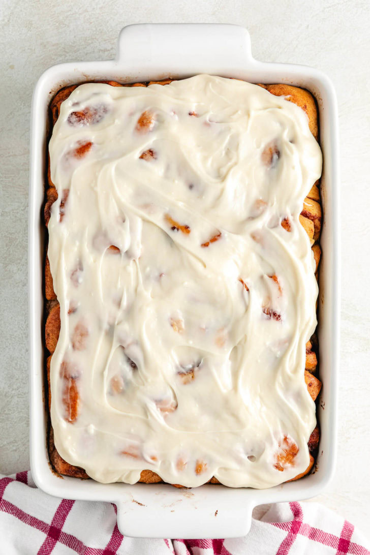 Frosted cinnamon roll french toast casserole in a pan.
