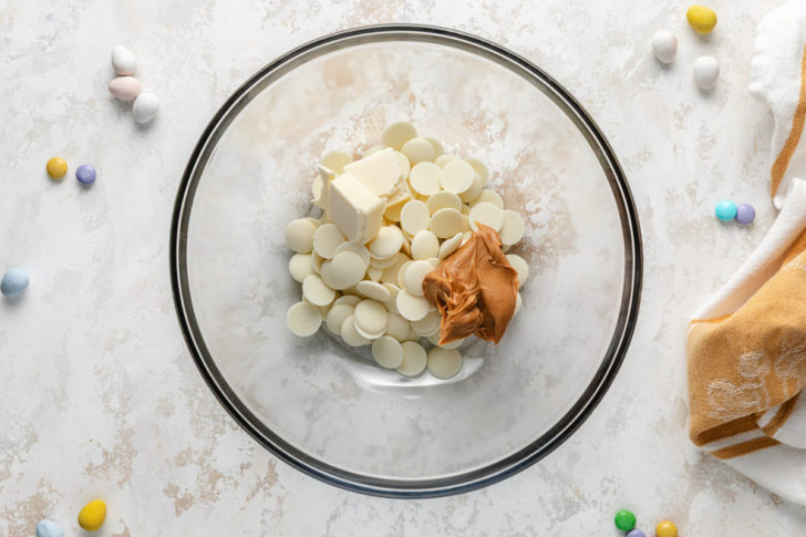 A bowl of vanilla melting wafers, peanut butter, and butter.