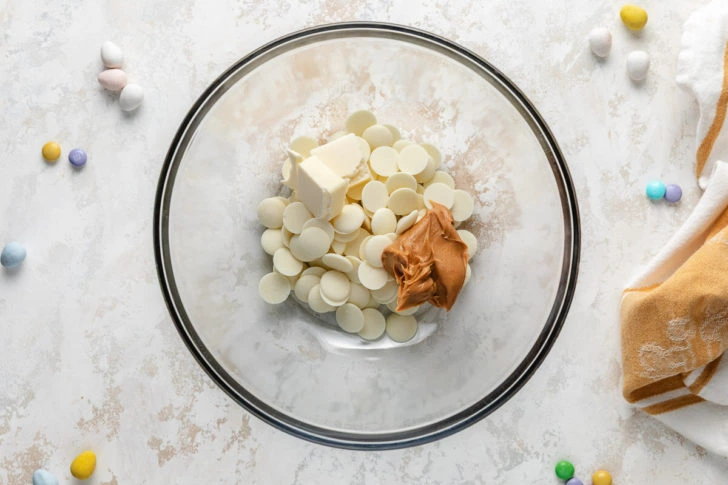 A bowl of vanilla melting wafers, peanut butter, and butter.