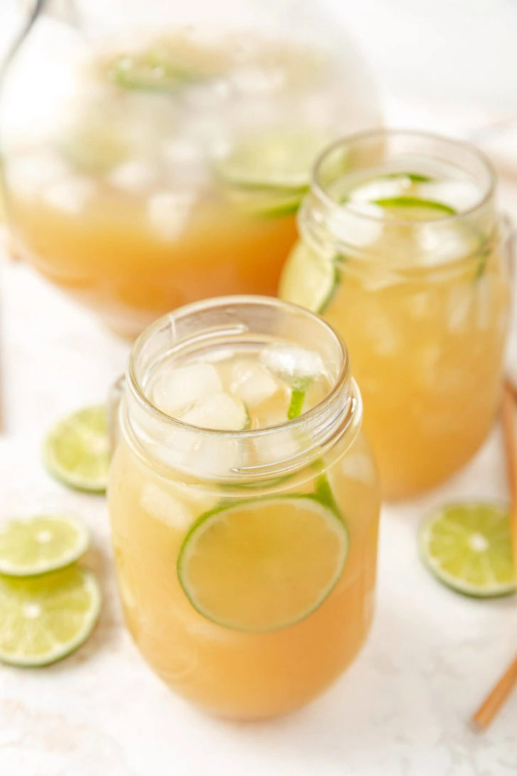 Glass jars with rum punch and lime slices.