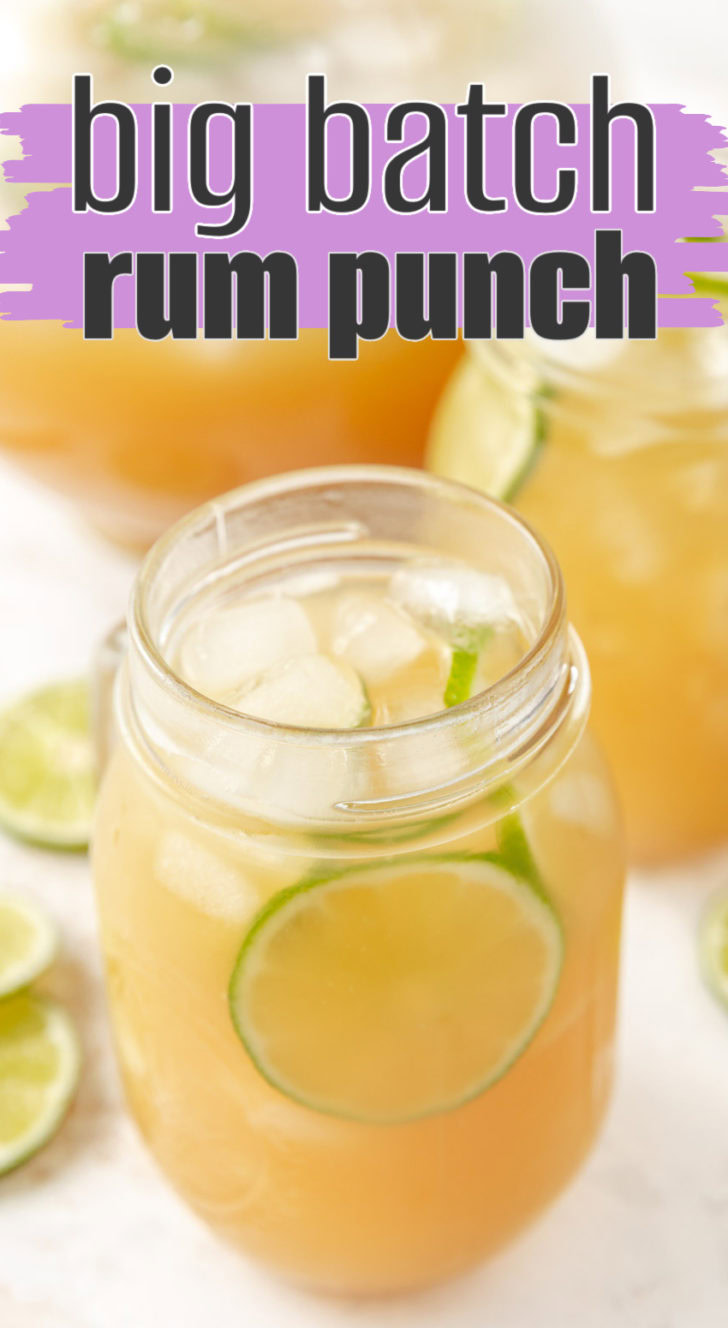 A glass jar with pineapple rum punch and lime.