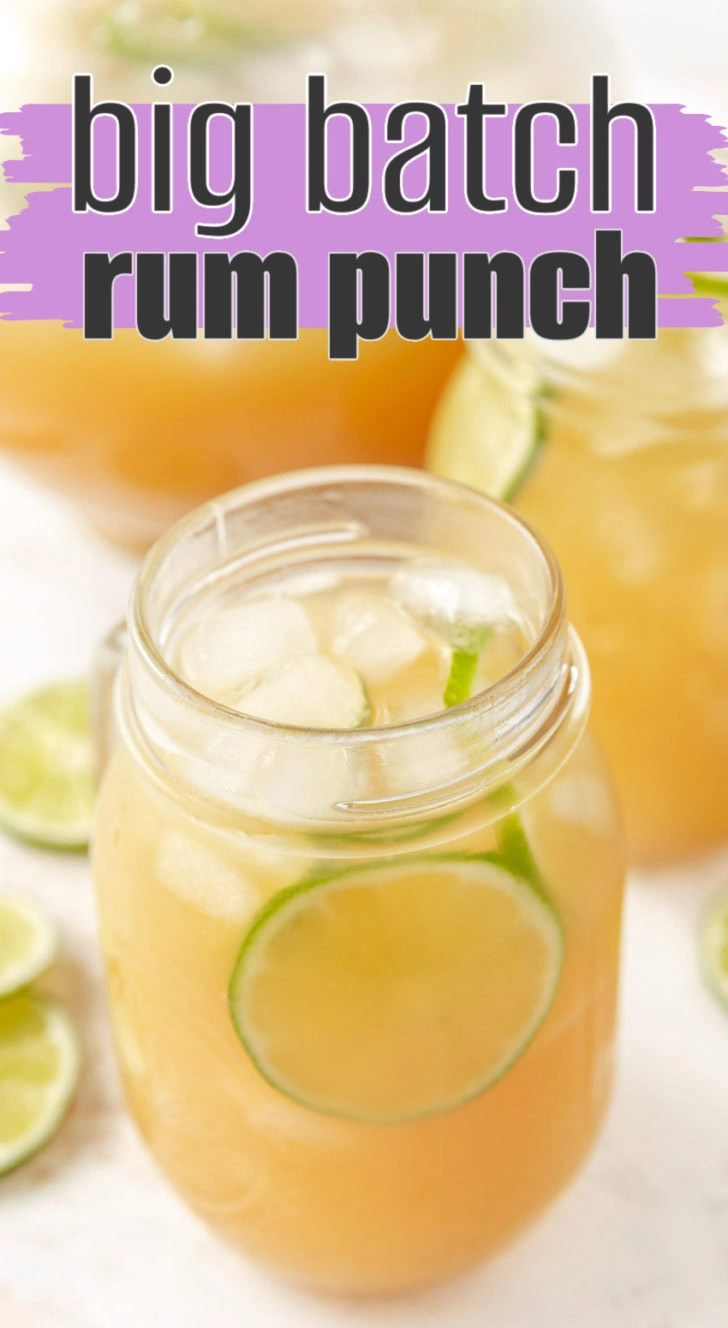A glass jar with pineapple rum punch and lime.