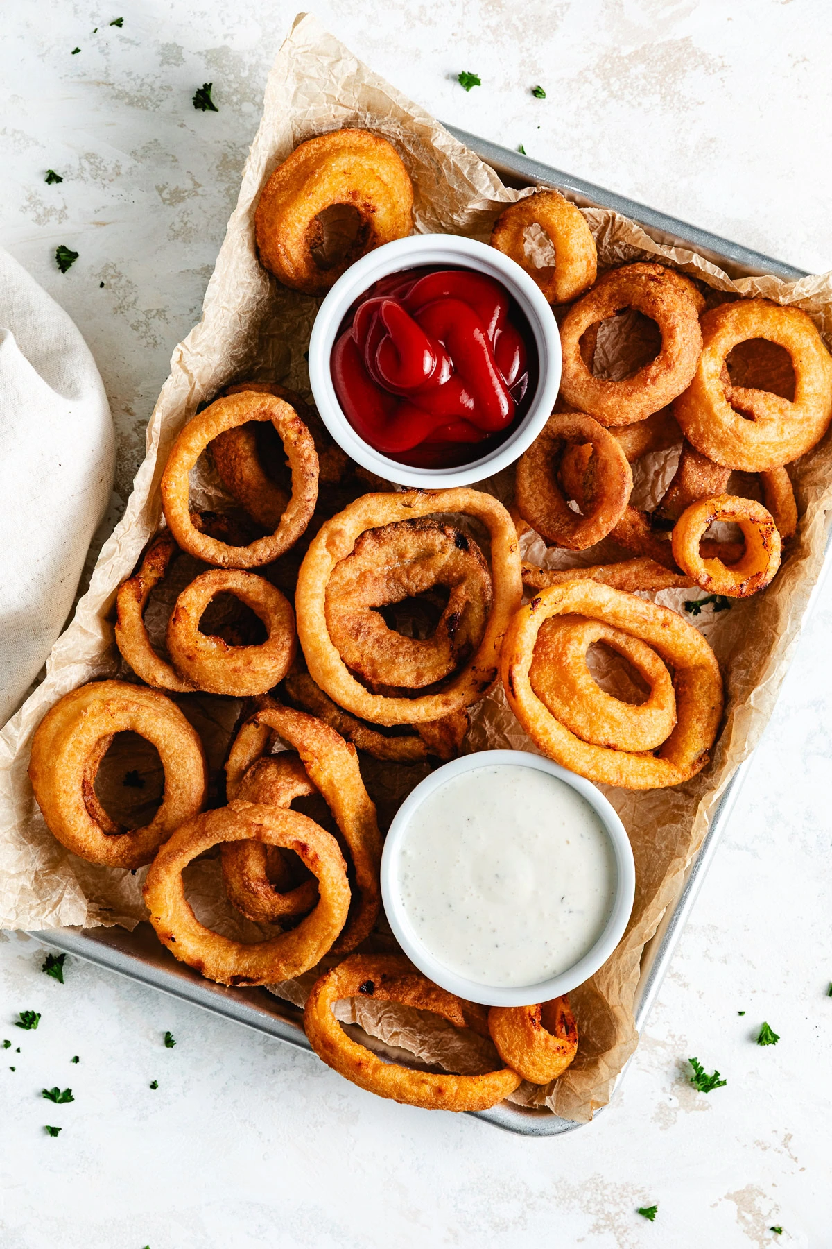 a tray of fried onion rings with sauces