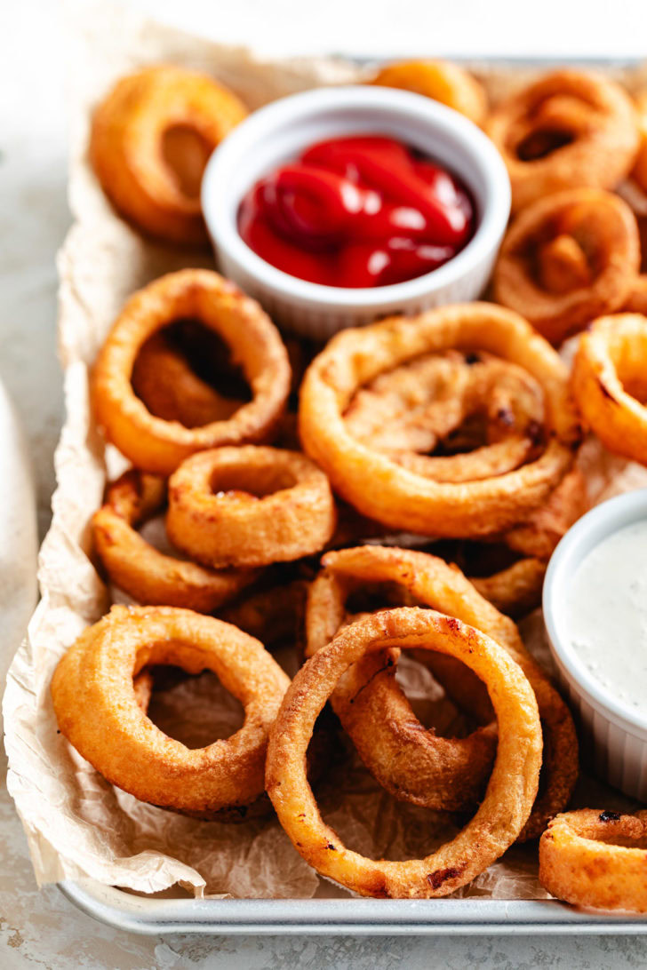 A plate of fried onion rings and sauces.