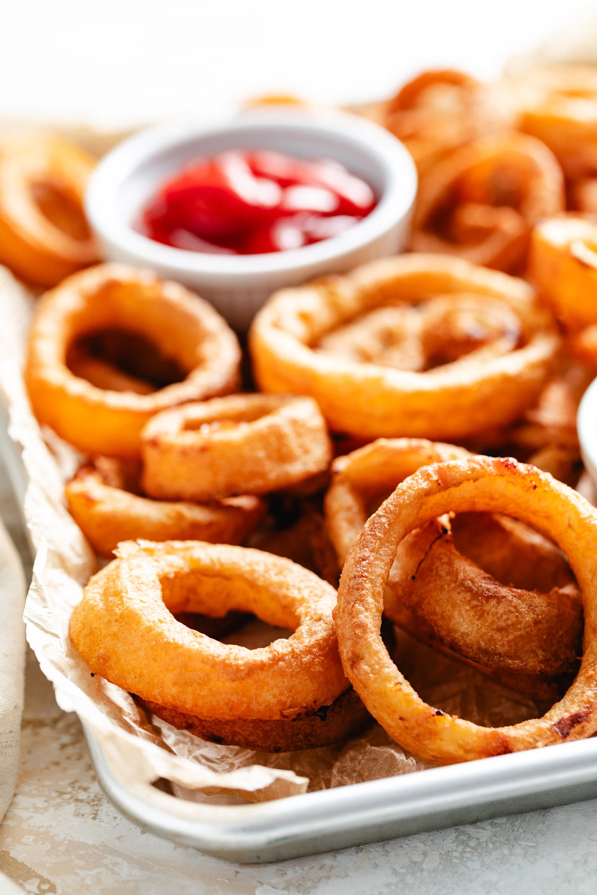 A plate of fried onion rings with ketchup.