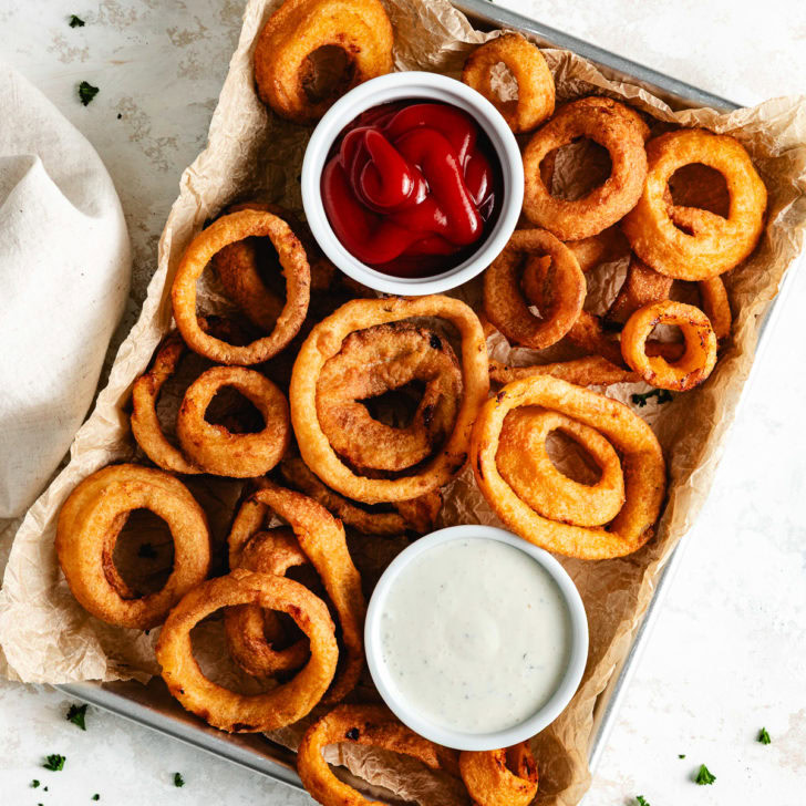 A tray of air fryer frozen onion rings and sauces.