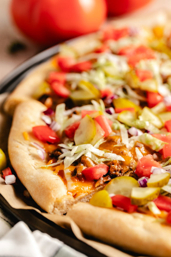 A pizza with toppings on a black pan.