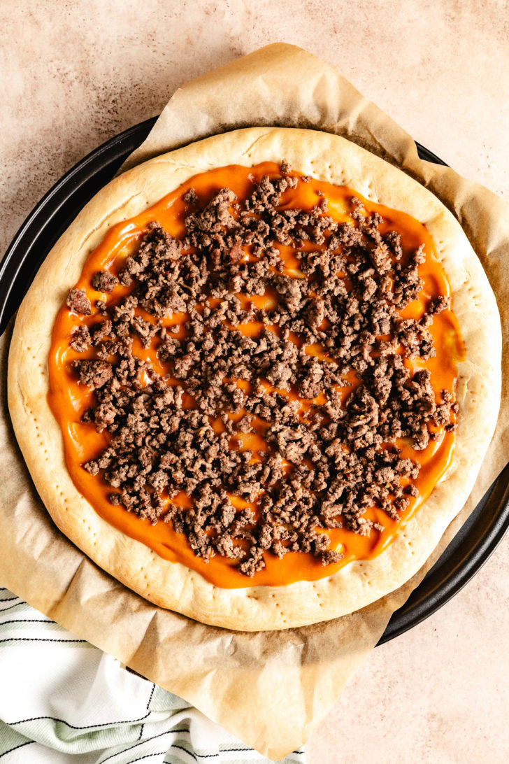 A pizza with seasoned ground beef.