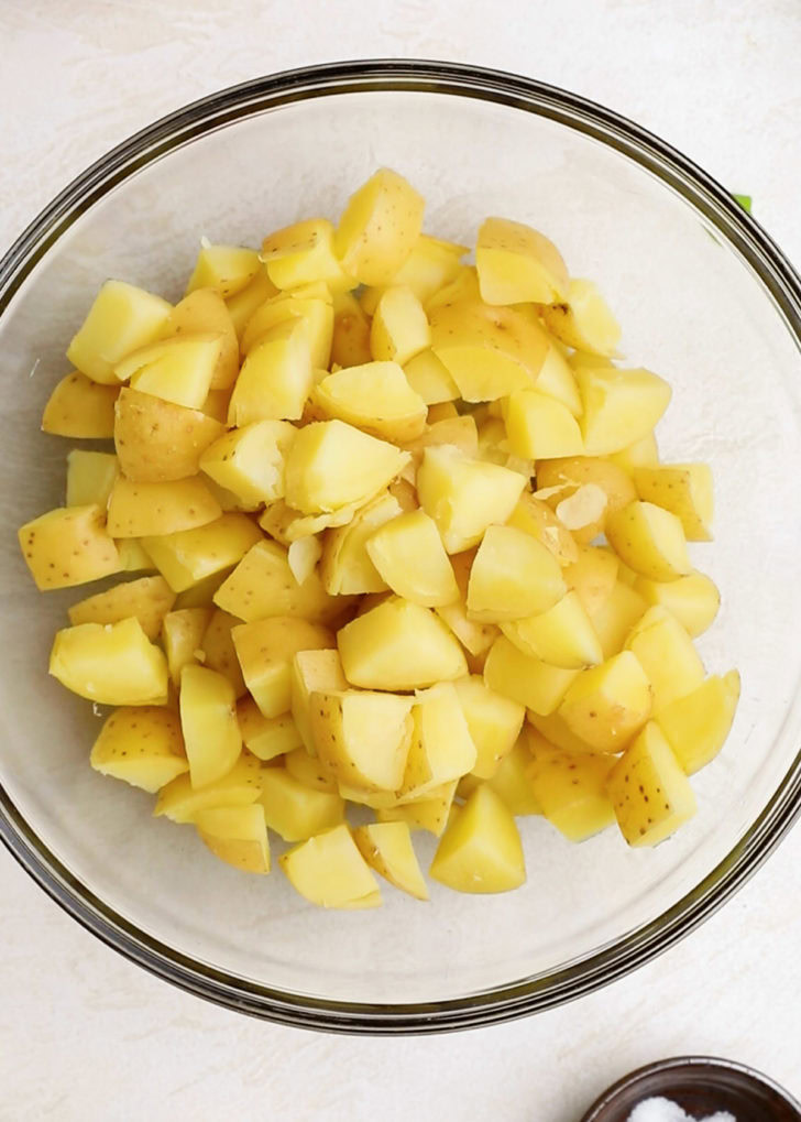 A bowl filled with diced potatoes.