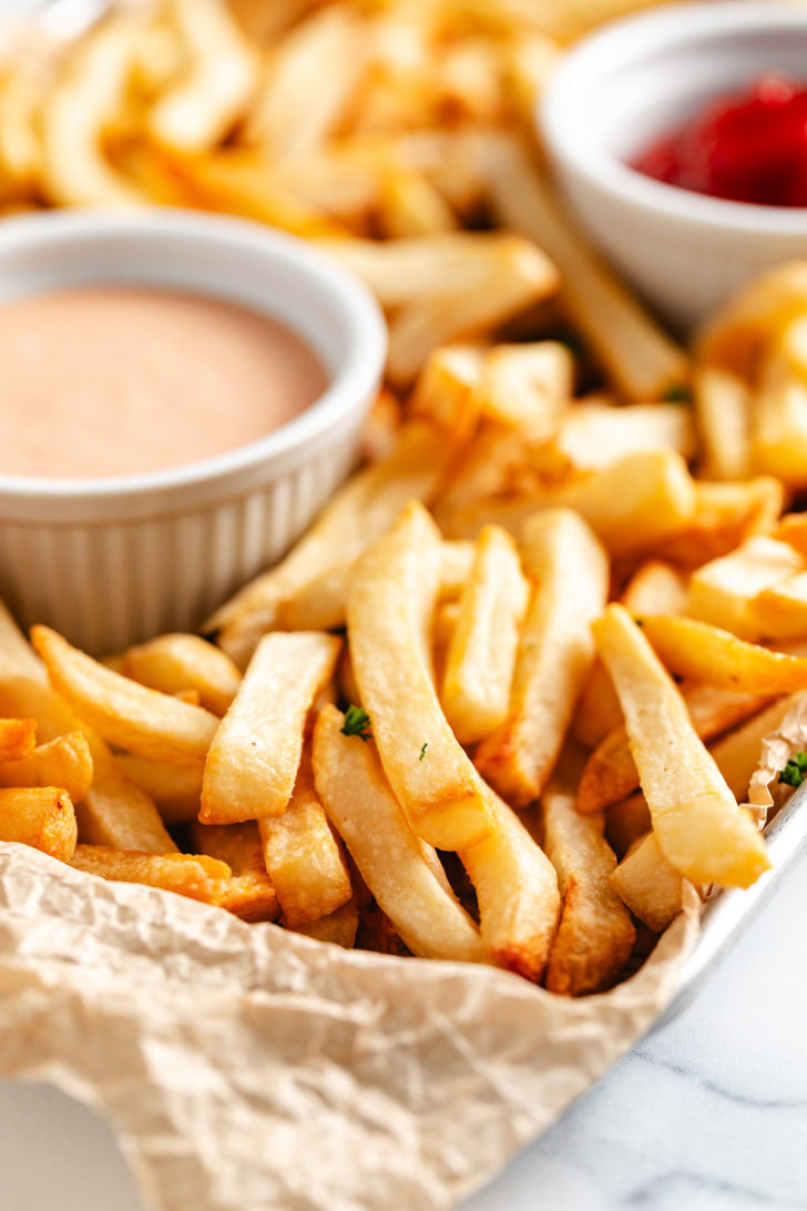 Golden brown french fries on parchment.